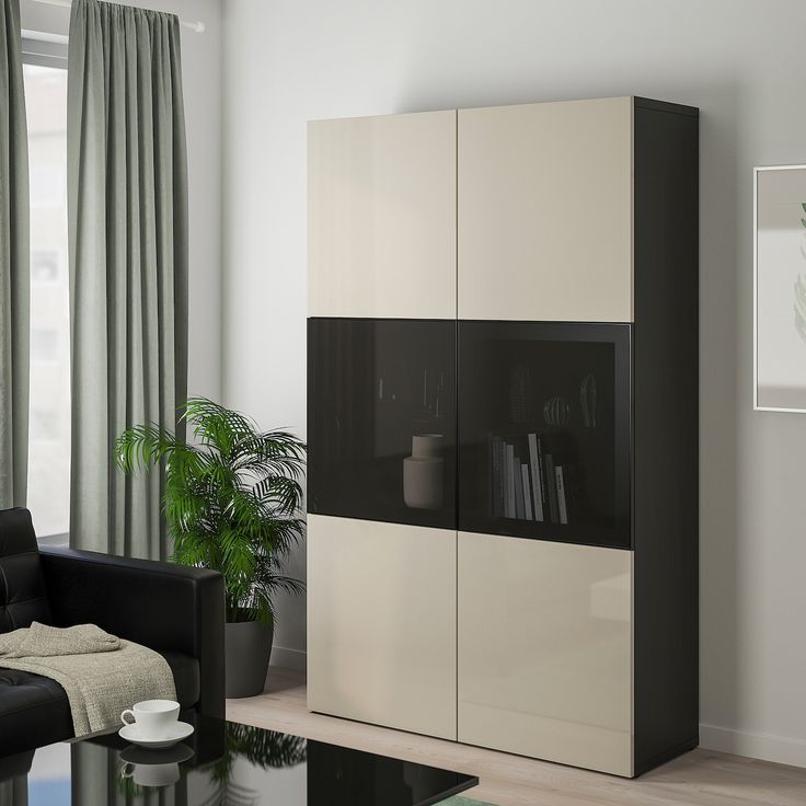 a black and white cabinet in a living room with a couch, coffee table and potted plant