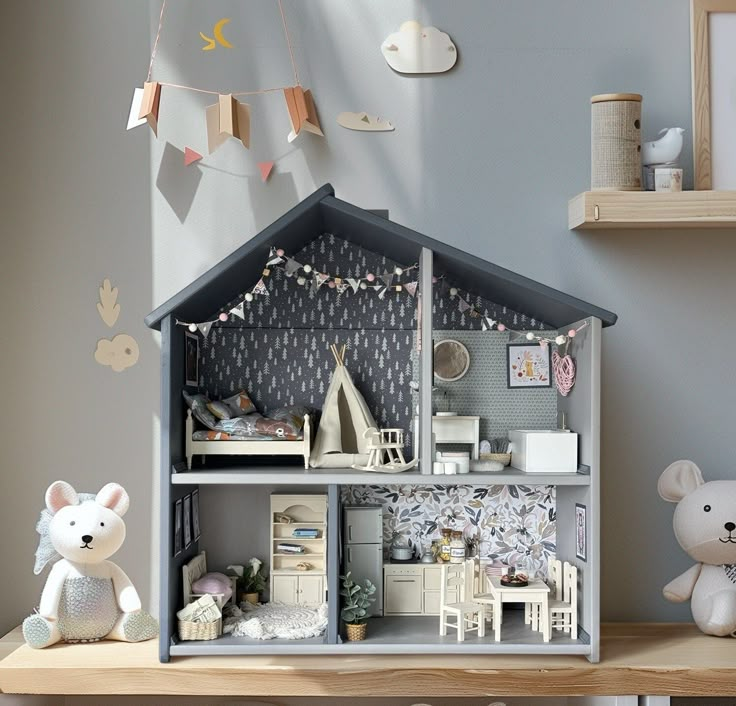 a doll house is shown with two teddy bears sitting on the table next to it