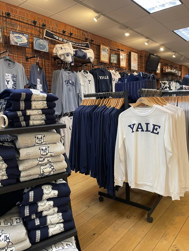 a clothing store filled with lots of shirts and t - shirts on display next to each other