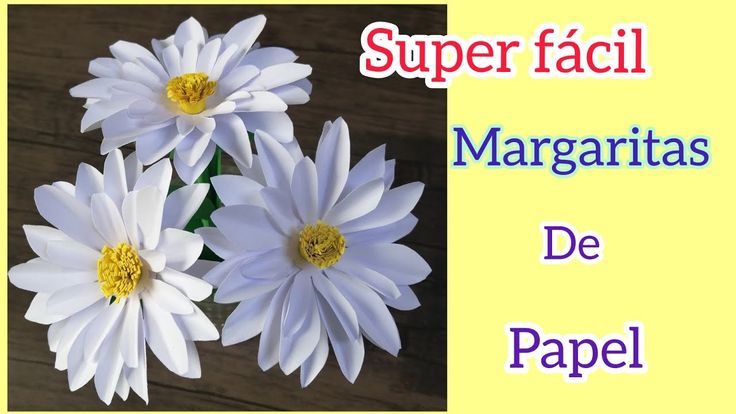 three white flowers sitting next to each other on top of a wooden table with the words super facii margaritas de papel