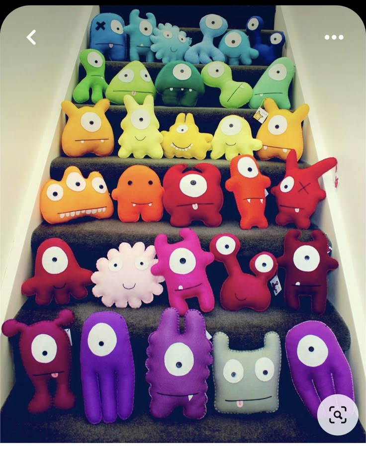 a set of stairs with different colored stuffed animals on the bottom and one in the middle