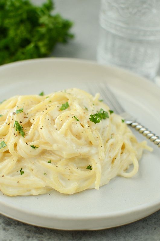 a white plate topped with pasta and parsley