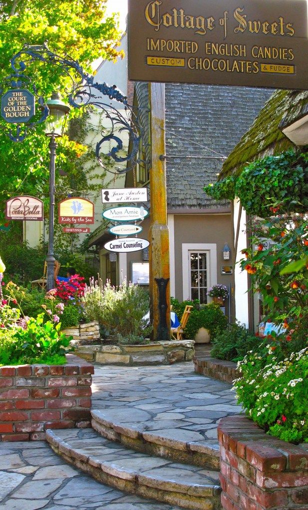 the entrance to cottage of sweets is decorated with flowers and greenery, along with stone steps