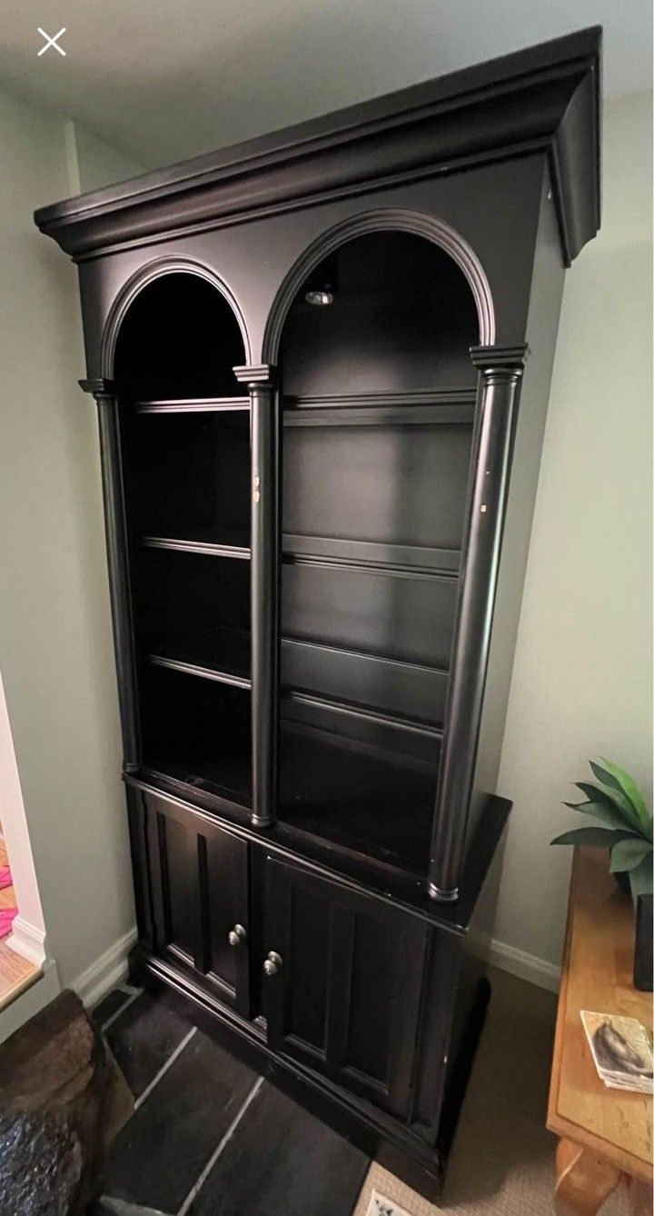 a black bookcase in the corner of a room