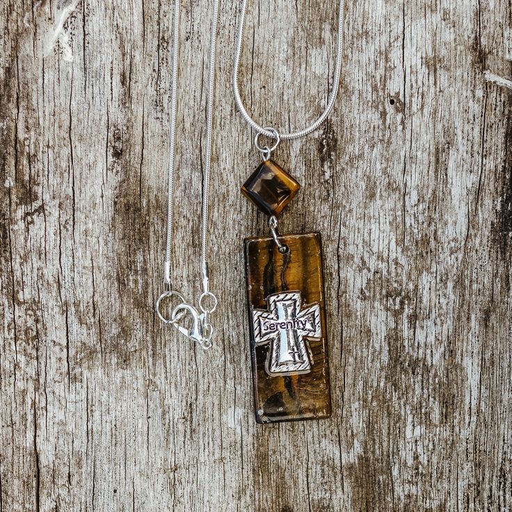 "Addiction Recovery Serenity Prayer AA necklace, Alanon necklace, NA necklace, Recovery jewelry, Gift for sponsor, Sobriety Gift Embrace the transformative power of recovery with our Tiger's Eye Necklace. Designed with a square diagonally drilled Tiger's Eye gemstone bead and a rectangular Tiger's Eye gemstone, this pendant exudes strength and hope. The cross stamped with the word \"Serenity\" adds a spiritual touch to this unisex AA necklace. Dangling gracefully from a 22-inch sterling silver chain, this piece serves as a tangible reminder of the Serenity Prayer and the principles of addiction recovery. Suitable for both men and women, this Alanon necklace is a meaningful and stylish accessory that symbolizes the unwavering commitment to a clean and sober life. Celebrate milestones and sh Personalized Spiritual Necklace With Rectangular Pendant, Spiritual Cross Pendant Necklace For Anniversary, Adjustable Cross Pendant Necklace As Gift, Adjustable Pendant Cross Necklace Gift, Spiritual Cross Pendant Necklace For Gift, Spiritual Cross Pendant Necklaces For Gift, Spiritual Cross Necklace With Large Pendant, Spiritual Square Pendant Necklace For Gift, Spiritual Nickel-free Necklaces For Memorial