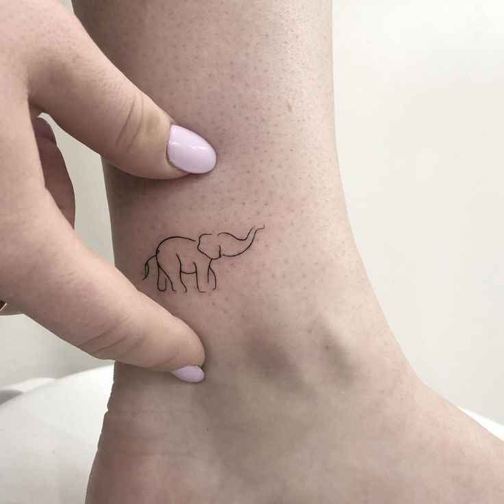 a woman's foot with a small tattoo of an elephant on her left ankle