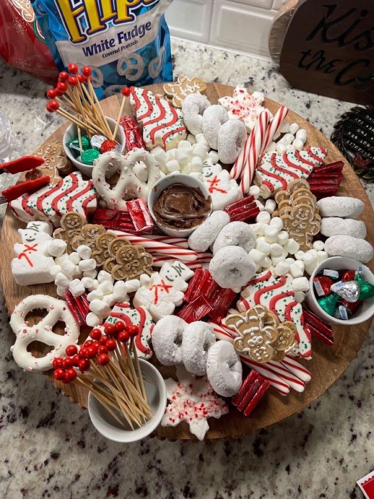 a wooden platter filled with candy and pretzels on top of a counter