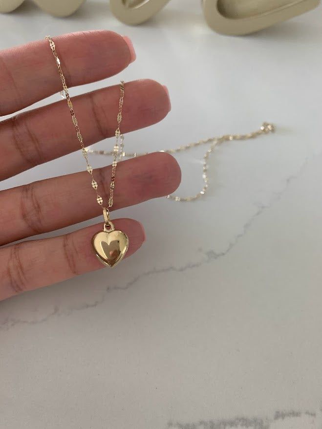 14KT Gold Heart Charm | 6mm, 10mm Puffed Heart Charm | Small Heart Charm | Real Gold Heart Pendant | Available in Yellow, White & Rose Gold | Large Pendant | Heart Necklace⁙ Materials: 14K Yellow Gold, Hollow Heart⁙ Pendant Dimensions: 12MM Width by 15MM Height, 4MM hoop ring diameter⁙ Chain Dimensions: 1.7 MM thick and 16", 18", 20", & 22" in length, it is a mirror diamond cut necklace MATERIALSAll chains are made of 14K Solid Gold HOW TO FIND YOUR PERFECT FITYour neck size is probably the most Heart Shape Locket Gold, Small Gold Heart Necklace, Gold R Necklace, Gold Heart Pendant Necklace, Latina Gold Jewelry, Heart Necklace Aesthetic, Necklace For Girlfriends, Gold Heart Jewelry