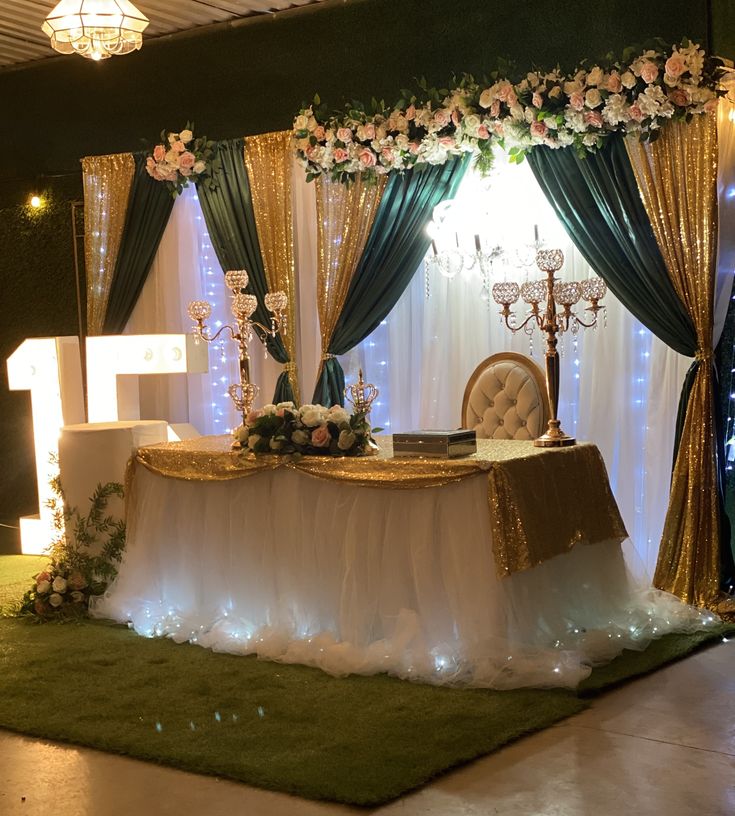 a table set up for a wedding with flowers and candles on it in front of a window