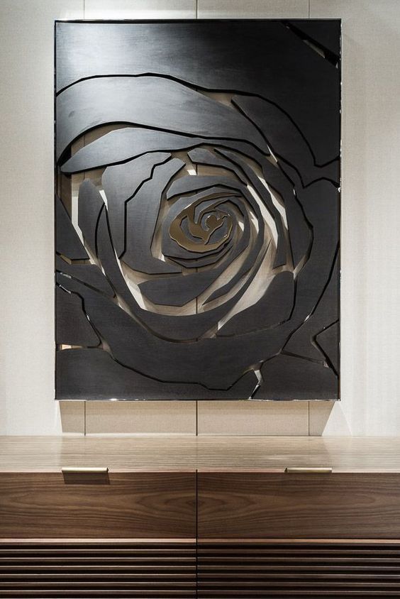 a large metal piece on top of a wooden table in front of a white wall