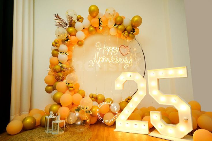 a happy anniversary sign surrounded by balloons and lights in the shape of a number twenty