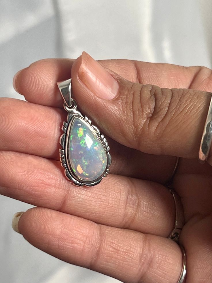 Embrace your best self with these magical Ethiopian Opal pendants. The brilliant southwest-styled setting and glowing teardrop stone make this exquisite pendant an excellent statement piece. Opals have been revered by many cultures for their unique mystical beauty and the belief that they protect against negative energy and soothe sadness. This lustrous pendant adds a touch of splendor to any outfit with its fiery hues. You won't be disappointed. Materials: .925 Sterling Silver, Ethiopian Opal A Bohemian Teardrop Large Stone Necklace, Handmade Teardrop Opal Jewelry, Opal Teardrop Jewelry With Natural Stones, Traditional Gemstone Teardrop Pendant Jewelry, Traditional Teardrop Pendant Gemstone Jewelry, Traditional Teardrop Gemstone Pendant, Unique Teardrop Stone-set Jewelry, Unique Teardrop Stone Setting Jewelry, Unique Teardrop Shaped Jewelry With Stone Setting