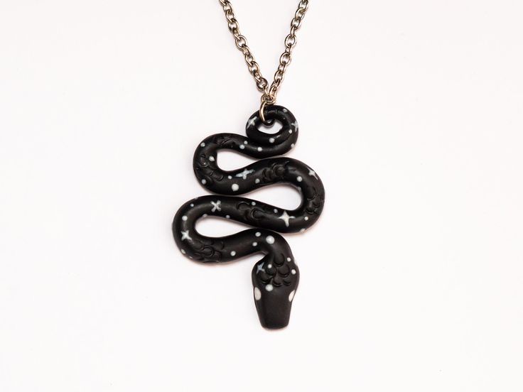 "Celestial Snake Pendant  Handmade Polymer Clay Necklace with Stainless Steel Chain ►►M A T E R I A L S ◄◄ * Polymer Clay * Stainless Steel ►►M E A S U R E M E N T S ◄◄ CHAIN *22in (51cm) +3in(7.5cm) extender PENDANT * Height 2.25 in (6cm)  * Width 1.5in (4cm) *measurements are approximate and may vary slightly per piece Jewellery is Handmade with every detail carefully refined to ensure the best quality. Due to the handmade nature of the items there may be slight variations from piece to piece and perfect \"imperfections\" Care instructions: - Acrylic paint is sealed with microcrystalline wax, however it can scratch off if handled roughly  - Please handle with care as this is a handmade product. - Avoid prolonged contact with water. - Polymer clay is durable and resistant but will break u Black Snake Necklace For Gifts, Elegant Black Snake-shaped Jewelry, Polymore Clay Snake Necklace, Handmade Black Snake-shaped Jewelry, Black Metal Snake-shaped Jewelry, Snake Pendant, Snake Jewelry, Polymer Clay Necklace, Polymer Clay Pendant