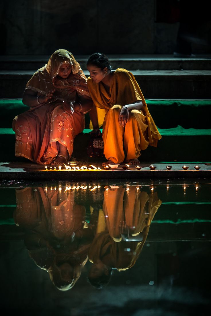 two women sitting on the ground next to each other