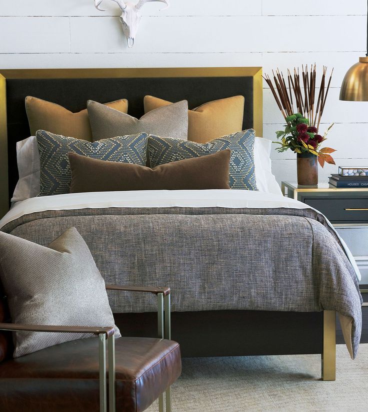 a bedroom with a bed, two chairs and a clock on the wall above it