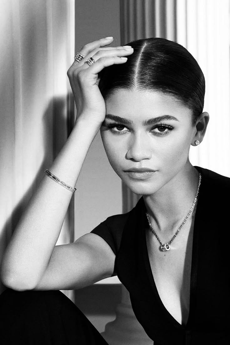 a black and white photo of a woman wearing jewelry