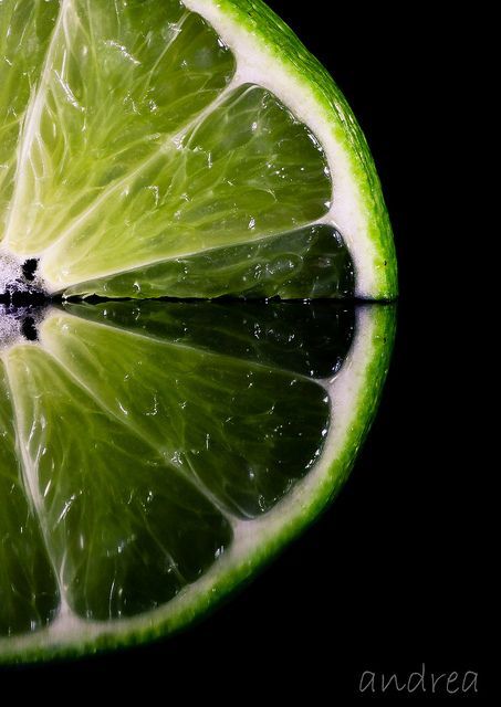 a slice of lime sitting on top of a black surface