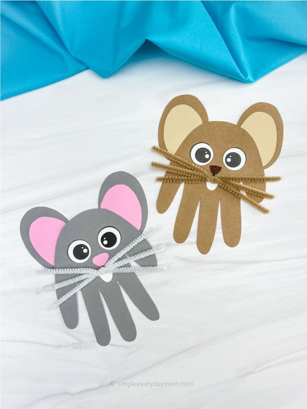 two paper mouses on a bed with blue sheets