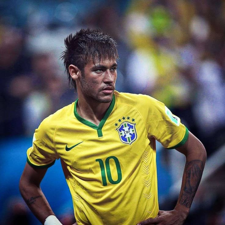 a soccer player with his hands on his hips looking at the camera while standing in front of an audience