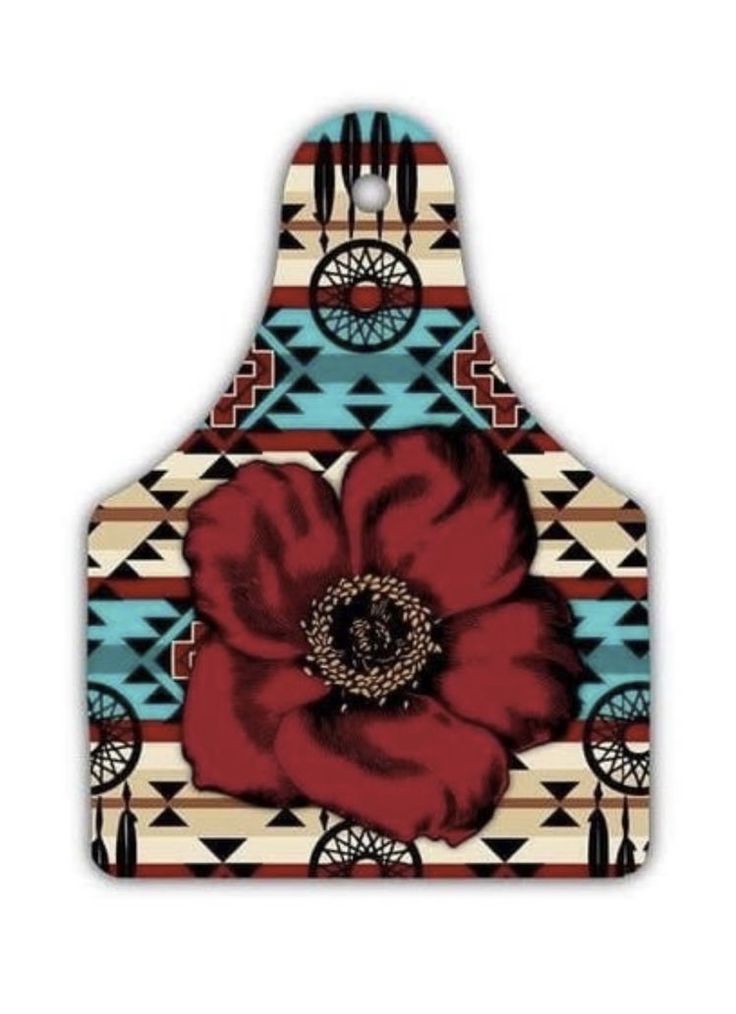 a red flower is sitting on top of a blue and white pot holder with geometric designs