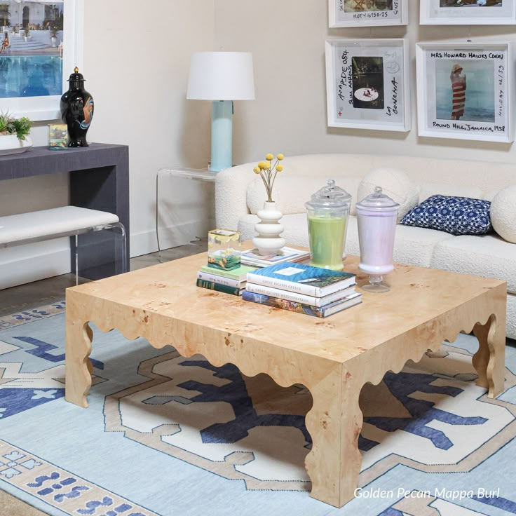 a living room filled with furniture and pictures hanging on the wall above it's coffee table