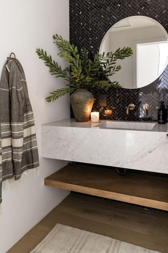 a bathroom with a sink, mirror and towel hanging on the wall next to it