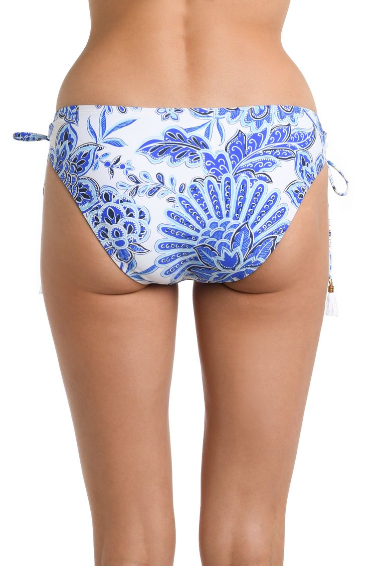 This swim collection features a captivating blue and white multicolored floral design pattern, reminiscent of ocean waves and blooming flowers. The blend of these cool tones on this hipster bottom evokes a sense of tranquility and elegance, making it an ideal choice for those seeking a sophisticated and stylish beachwear option. [split] Details Hipster bottom Adjustable loop side ties White tassel charms Moderate coverage in the back Fabric 83% Nylon, 17% Elastane Printed Poolside Bottoms For Vacation, Printed Bottoms For Poolside Vacation, Printed Vacation Bottoms For Poolside, Printed Tie-side Pool Bottoms, Printed Tie-side Bottoms For Pool, Stretch Printed Bottoms For Pool, Printed Bottoms For Poolside And Beach Season, Floral Print Stretch Bottoms For Pool, Stretch Floral Print Bottoms For Pool