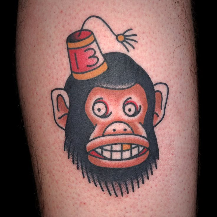 a monkey with a party hat on his head is featured in this tattoo design by the artist