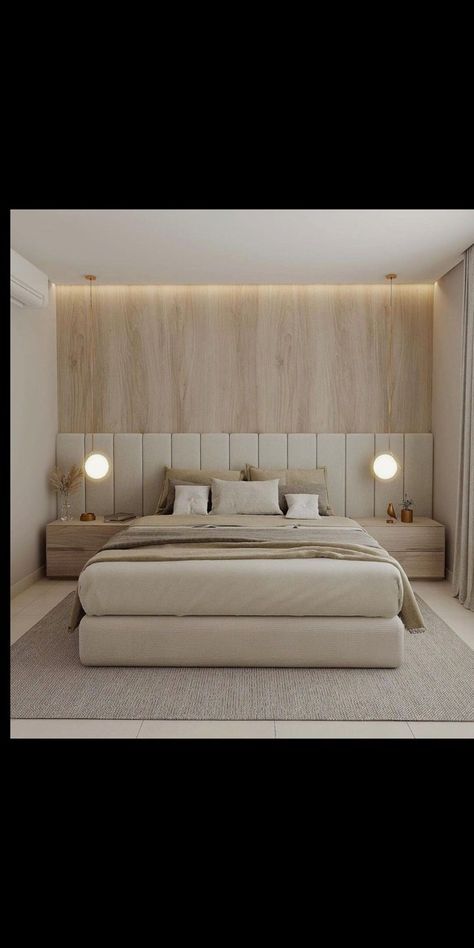 a large white bed sitting in a bedroom next to a wall mounted light above it