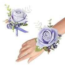 two purple roses and greenery are on the wrist of someone's hand as they both wear matching bracelets