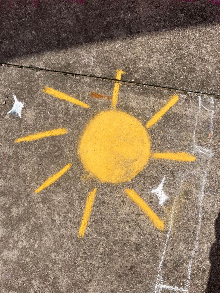 the sun is drawn on the sidewalk with yellow paint