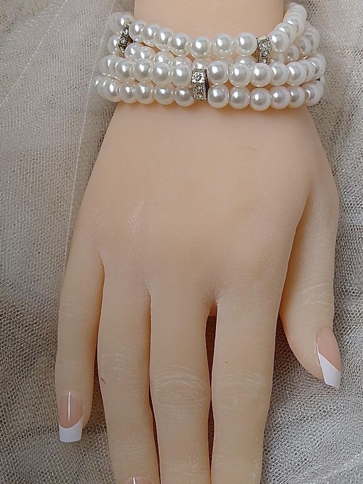 Very pretty white pearl bracelet with rhinestone detail. This is a stretch bracelet that can fit any wrist size. Very comfortable to wear. You get two individual bracelets that have two strands of pearls each. You can wear one at a time or stack both together for a wider bracelet look. This will look great with your wedding gown. Accessorize with pearl earrings, and you are good to go! White Pearl Bracelet With Charm For Party, White Pearl Drop Bracelets For Party, Elegant Pearl Beaded Stretch Bracelet, White Pearl Beaded Bracelets For Party, White Pearl Bracelet For Party, Elegant Beaded Pearl Stretch Bracelet, Elegant White Beaded Stretch Bracelet, White Pearl Stretch Bracelet With Pearl Charm, Elegant White Stretch Bracelet With Pearl Charm