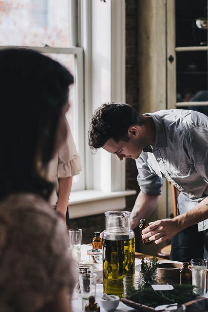 a man standing over a table filled with glasses