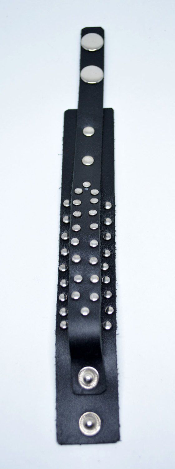 Genuine mens black leather studded bracelet with adjustable snap closure at the end. High quality handmade item, suitable for a modern urban look. Fits both men and women. Fit wrists from: 17 cm (6.69") 19 cm (7.48") to 22 cm (8.66") Width is about 3 cm (1.18") Trendy Black Bracelets With Rivets, Black Edgy Wristband With Studs, Black Leather Bracelet With Rivets For Concerts, Adjustable Black Wristband With Rivets, Black Trendy Bracelets With Studs, Trendy Black Bracelets With Studs, Black Riveted Bracelets For Concerts, Black Metal Bracelet With Rivets, Edgy Black Cuff Bracelet With Rivets