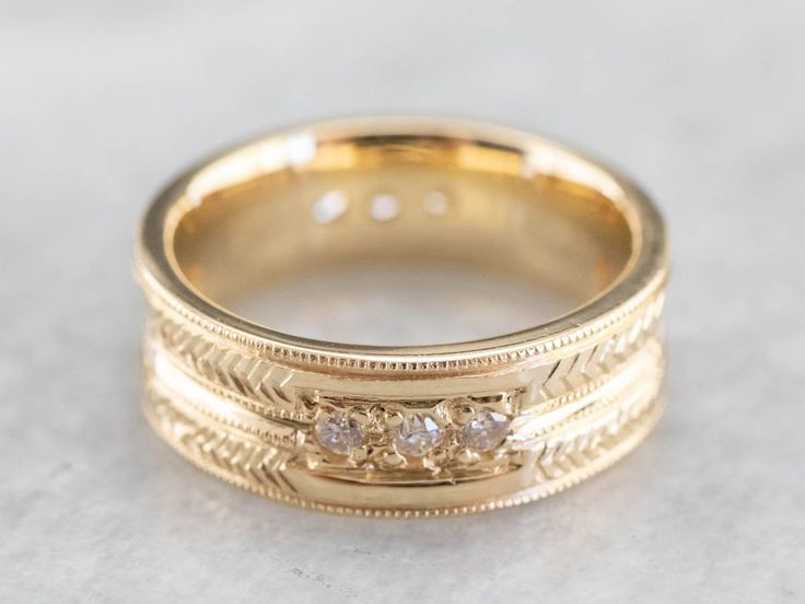 This engraved band is of a perfect heft and shape to feel soft and pleasant on the finger. It is both pretty and sophisticated, and it would be a great wedding or stacking band for a woman who wants a little extra sparkle but works with her hands. Metal: 18K Yellow Gold Gem: 12 Diamonds totaling .36 Carats, F in Color, VVS in Clarity Width of Band: 6.5 mm Height off Finger: 1.9 mm Ring Size: 6 Marks: "AA18K" Stamped on the inside band 14k Gold Bands With Diamond Accents, Thick Band Jewelry With Single Cut Diamonds For Wedding, Wedding Ring With Single Cut Diamonds And Thick Band, Luxury Stackable Wedding Bands, Yellow Gold Diamond Ring With Decorative Band, Yellow Gold Diamond Band With Decorations, Luxury Stackable Rings With Thick Band For Wedding, 14k Gold Band With Single Cut Diamonds, Fine Jewelry Engraved Ring With Decorative Band