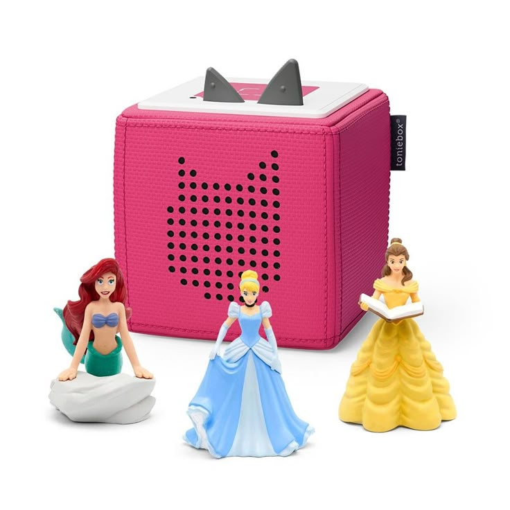 three princess figurines sitting next to a pink radio