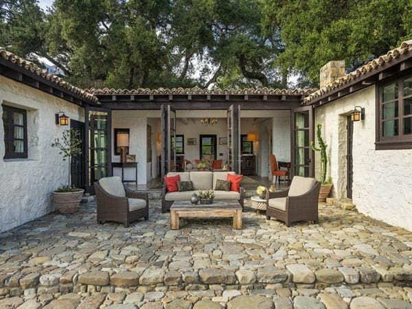 an outdoor living area with stone flooring and furniture