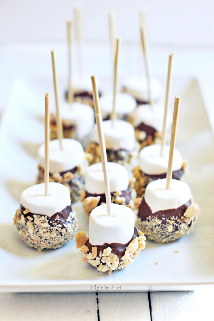 mini marshmallows are arranged on a white plate with sticks sticking out of them