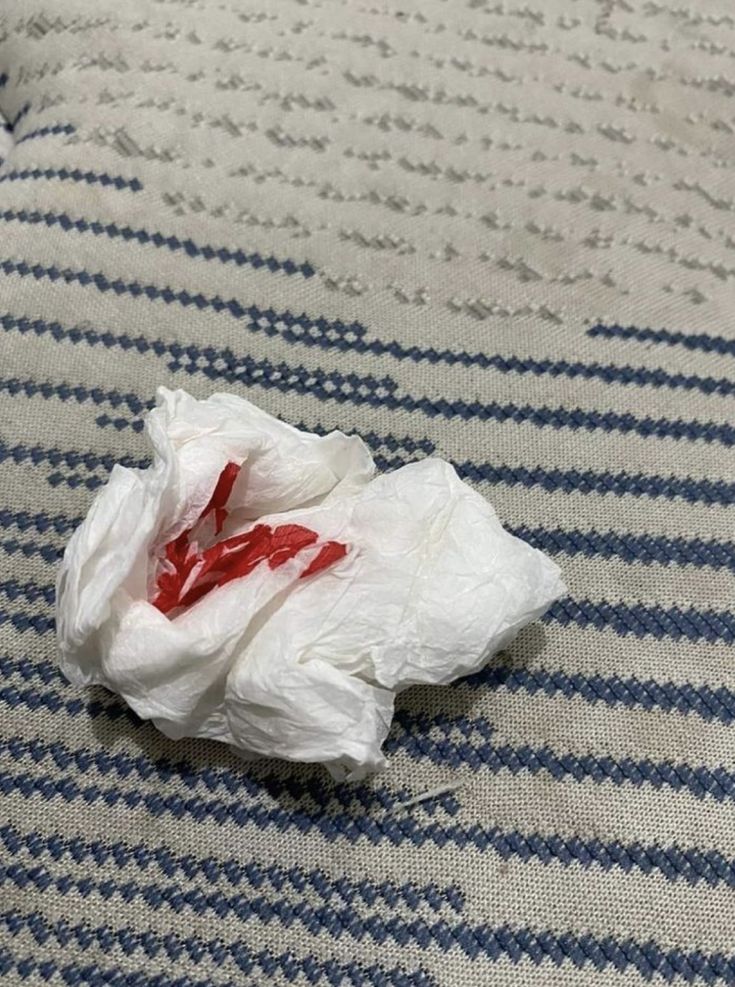 a piece of cloth that has been placed on a bed with some red and white things in it