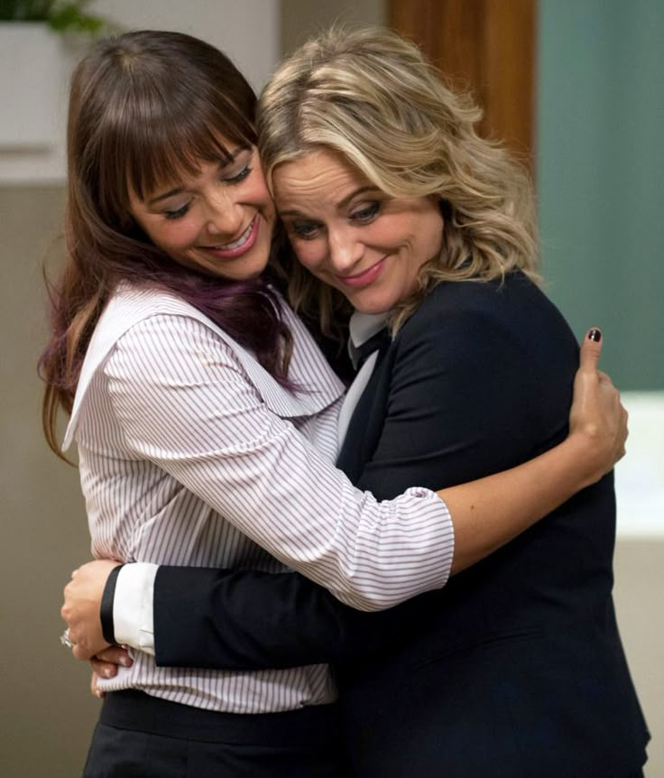 two women hugging each other and smiling