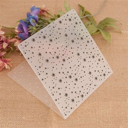 a white card with stars on it next to some purple and blue flowers in front of a beige background