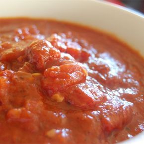 a white bowl filled with lots of red sauce