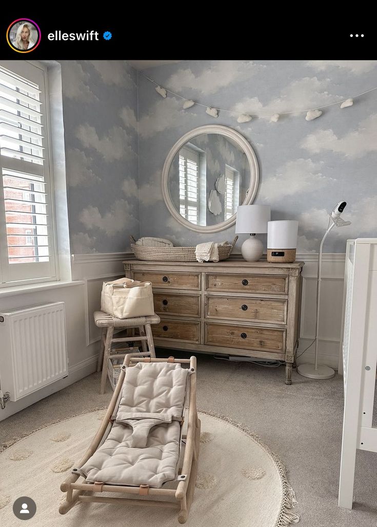 a baby's room with clouds painted on the wall and furniture in the foreground