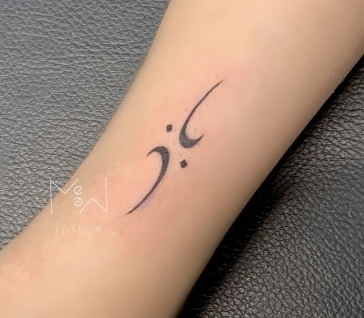 a small arabic calligraphy tattoo on the arm