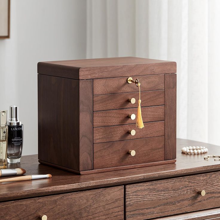 a wooden jewelry box sitting on top of a dresser