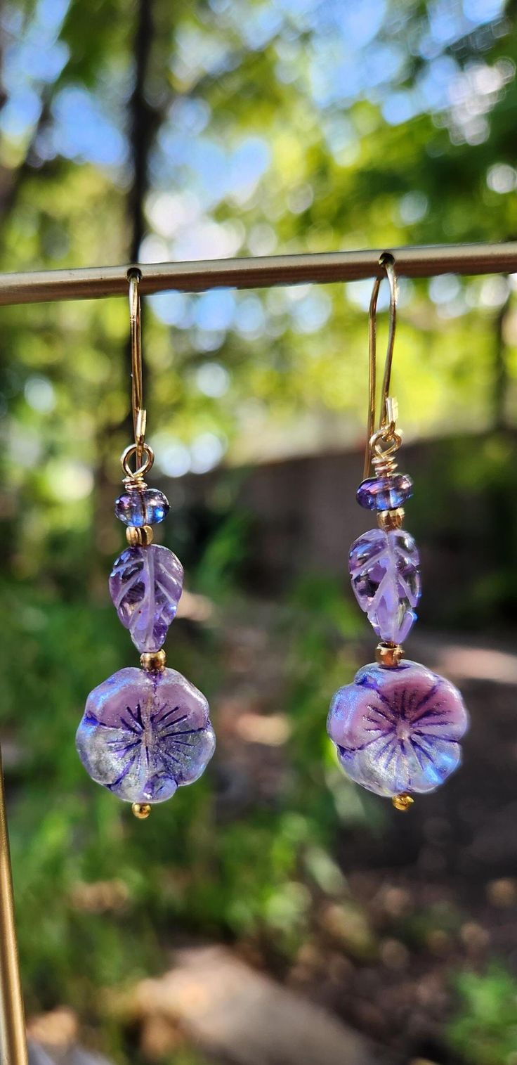 The centerpiece for these extraordinary earrings are handmade, carved amethyst leaves -- purple Beautiful varied shades of purple.  The flowers compliment the leaves.  Czech glass accent beads and brass spacers accent the Boho look.  These earrings are exquisite.  The overall effect is sassy Boho.   The one of a kind earrings are 2 inches in length, including the gold plated ear wire hooks.  All the beads are two sided.   Unique. Handmade. Lightweight. Smoke free artist studio. **If you prefer lever back hooks, just let me know and I will change the hooks at no charge. Purple Czech Glass Earrings For Gift, Lavender Amethyst Earrings With Ear Wire, Lavender Amethyst Drop Earrings, Hypoallergenic Purple Flower Jewelry, Handmade Purple Crystal Drop Earrings, Handmade Lavender Drop Earrings, Adjustable Purple Jewelry With Lever Back Ear Wires, Hypoallergenic Purple Bohemian Earrings, Handmade Lavender Crystal Drop Earrings