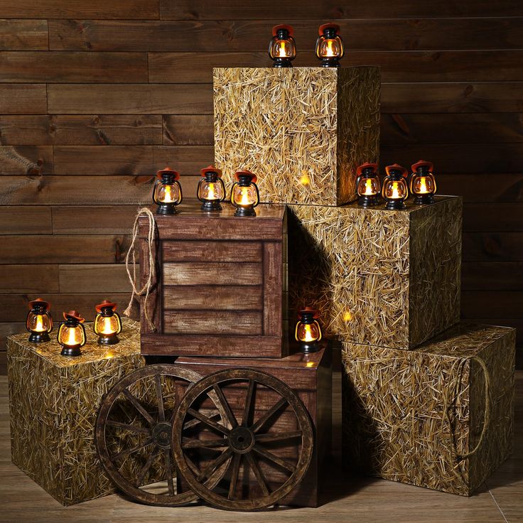 an old wooden wagon with many lights on it next to hay bales and other items