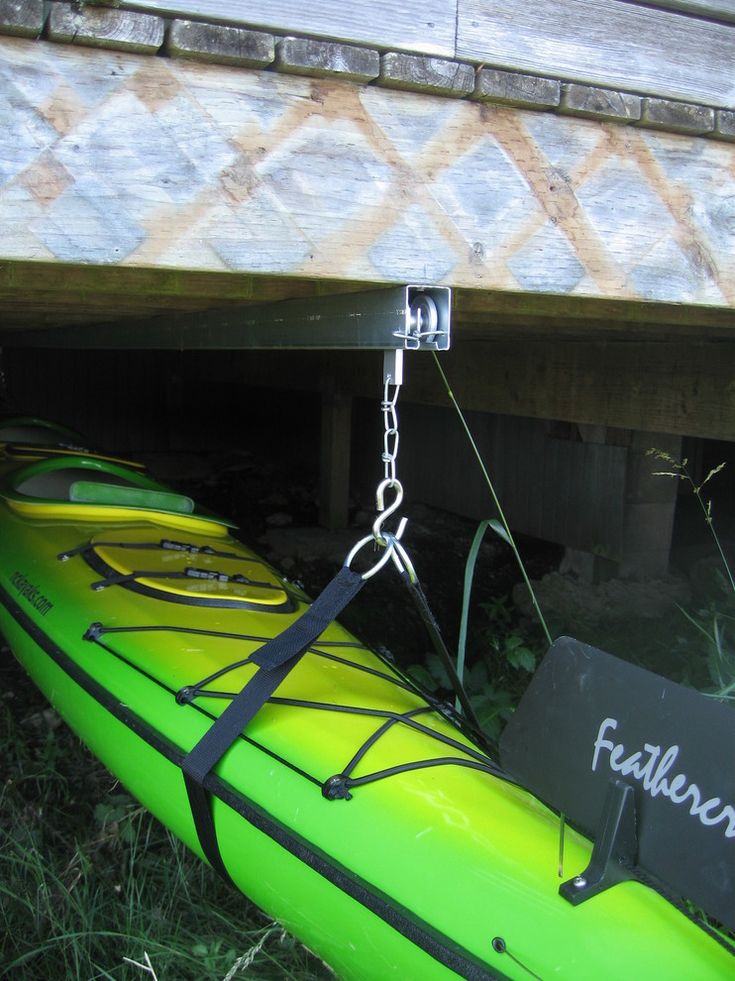 two kayaks are tied to the side of a building with chains hanging from them