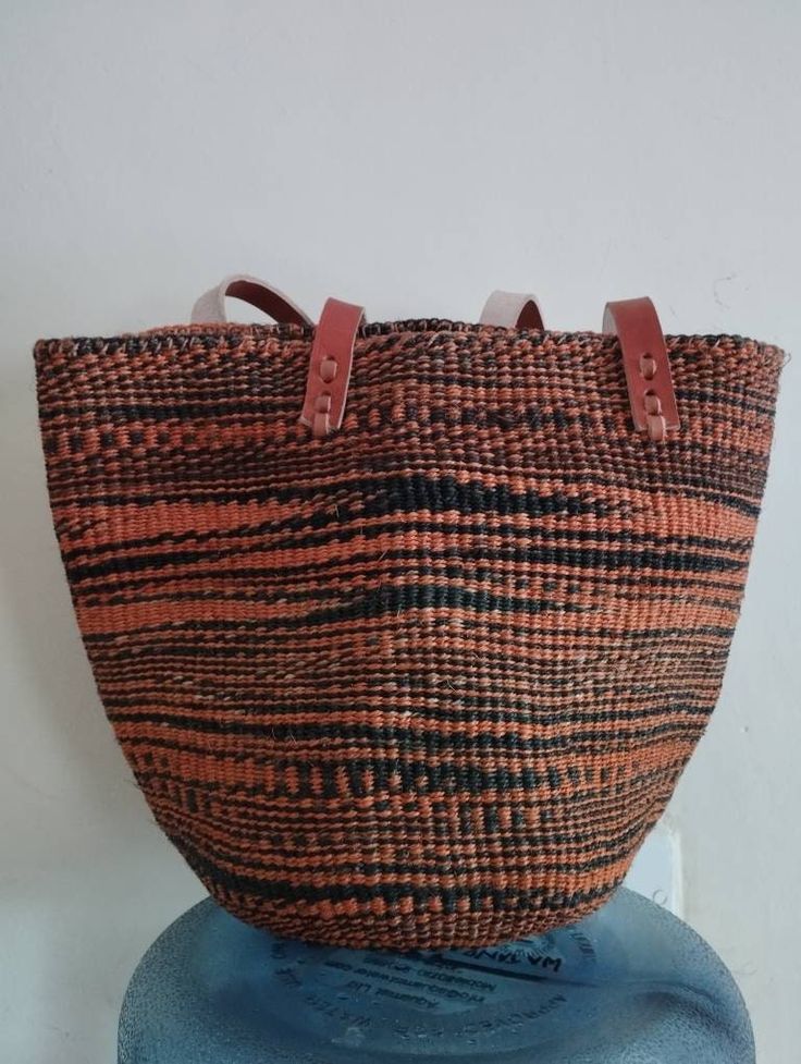 "Black and orange sisal tote bag DIMENSIONS Bottom width: 10\"/25.5cm Top width: 14\"/35.56cm Depth: 10\"/25.5cm Straps: 15\"/38cm SHIPPING All orders ship via DHL Express (3-5) days delivery time." Black Handheld Handwoven Straw Bag, Eco-friendly Handheld Beach Bag With Leather Handles, Handwoven Black Straw Tote Bag, Handwoven Double Handle Bag For Daily Use, Black Handwoven Straw Tote Bag, Handwoven Double Handle Shoulder Bag For Daily Use, Handwoven Shoulder Bag With Double Handle For Daily Use, Black Handwoven Crochet Bucket Bag, Daily Use Handwoven Shoulder Bag With Double Handle