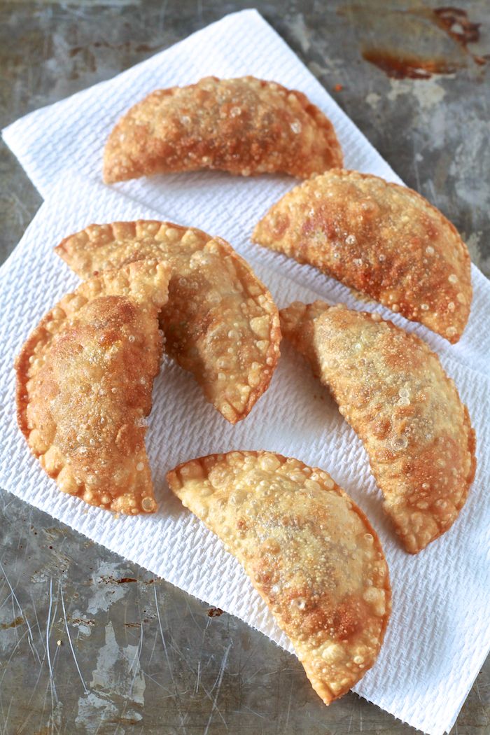 four fried pastries sitting on top of a white napkin